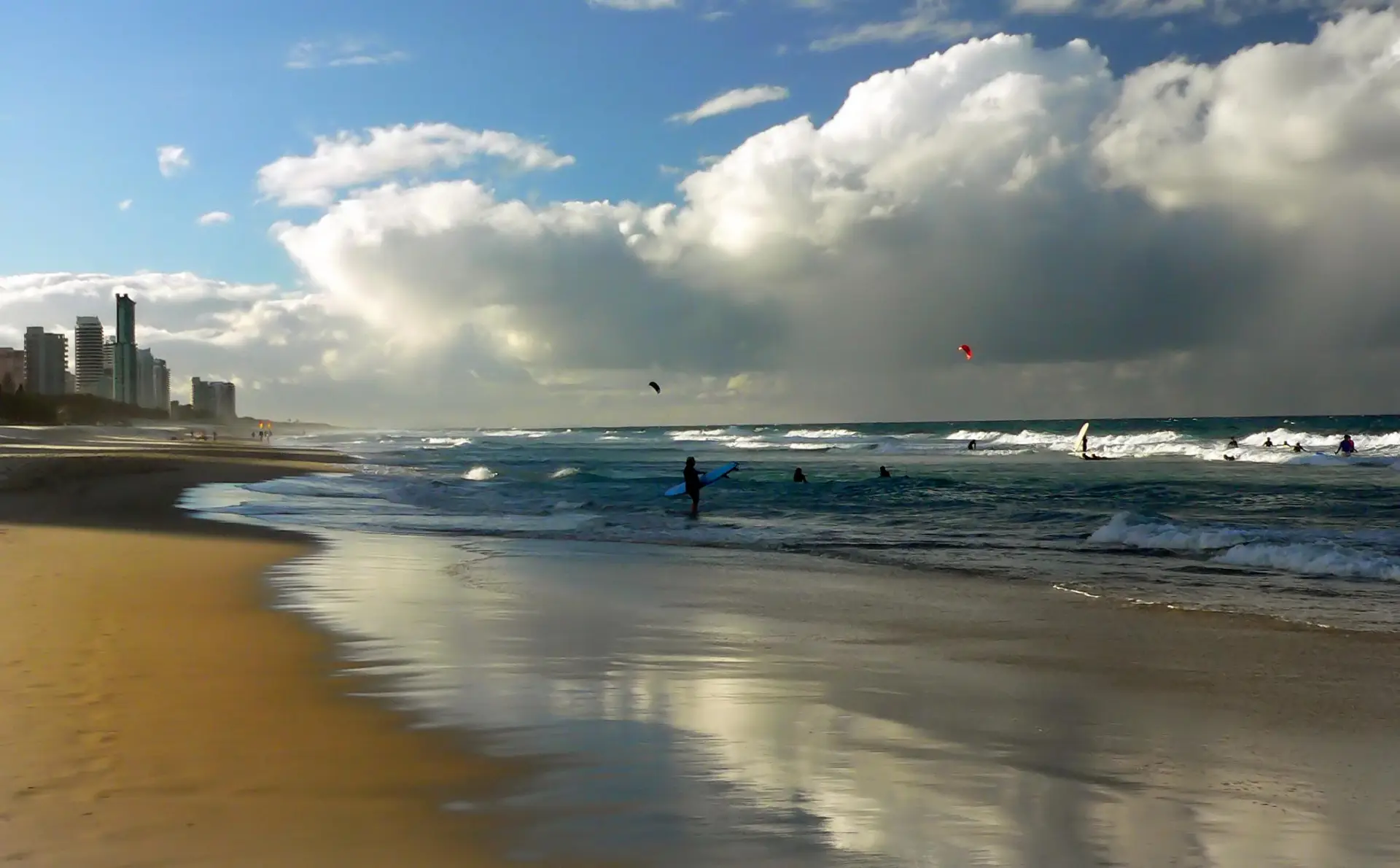 Surfers in the water at Surfers Paradise Beach, towers down the shoreline